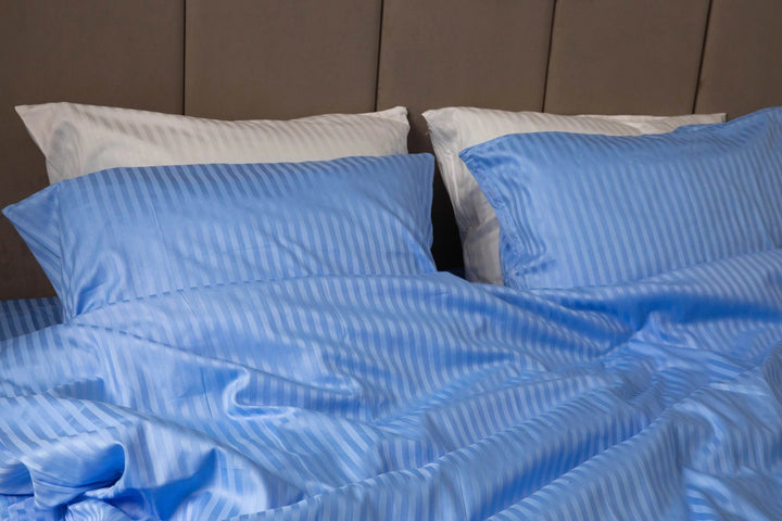 Близький план фактури сатинової тканини синього кольору зі смужками.