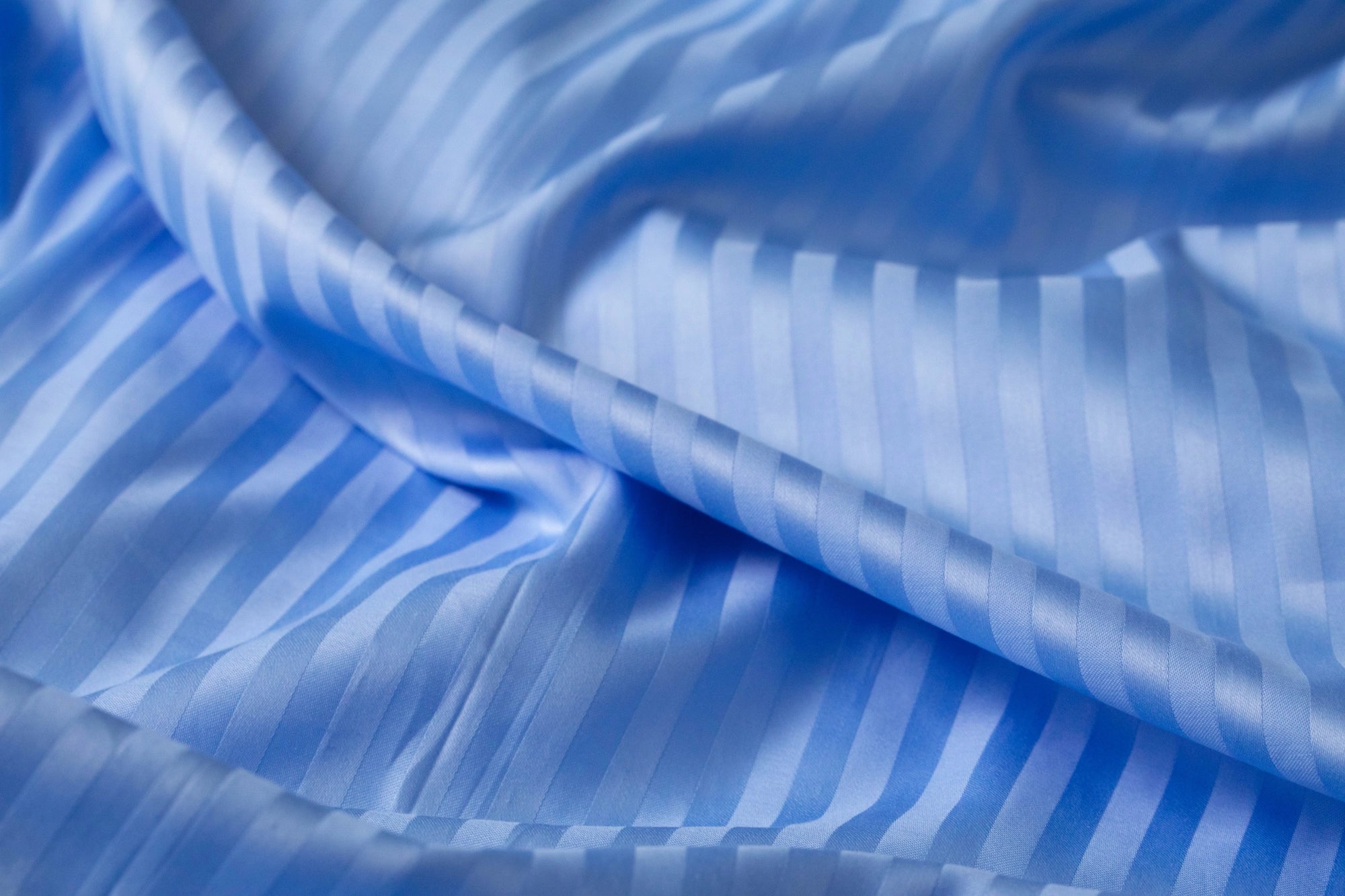 Блакитна сатинова тканина з легким блиском та ідеальними швами.