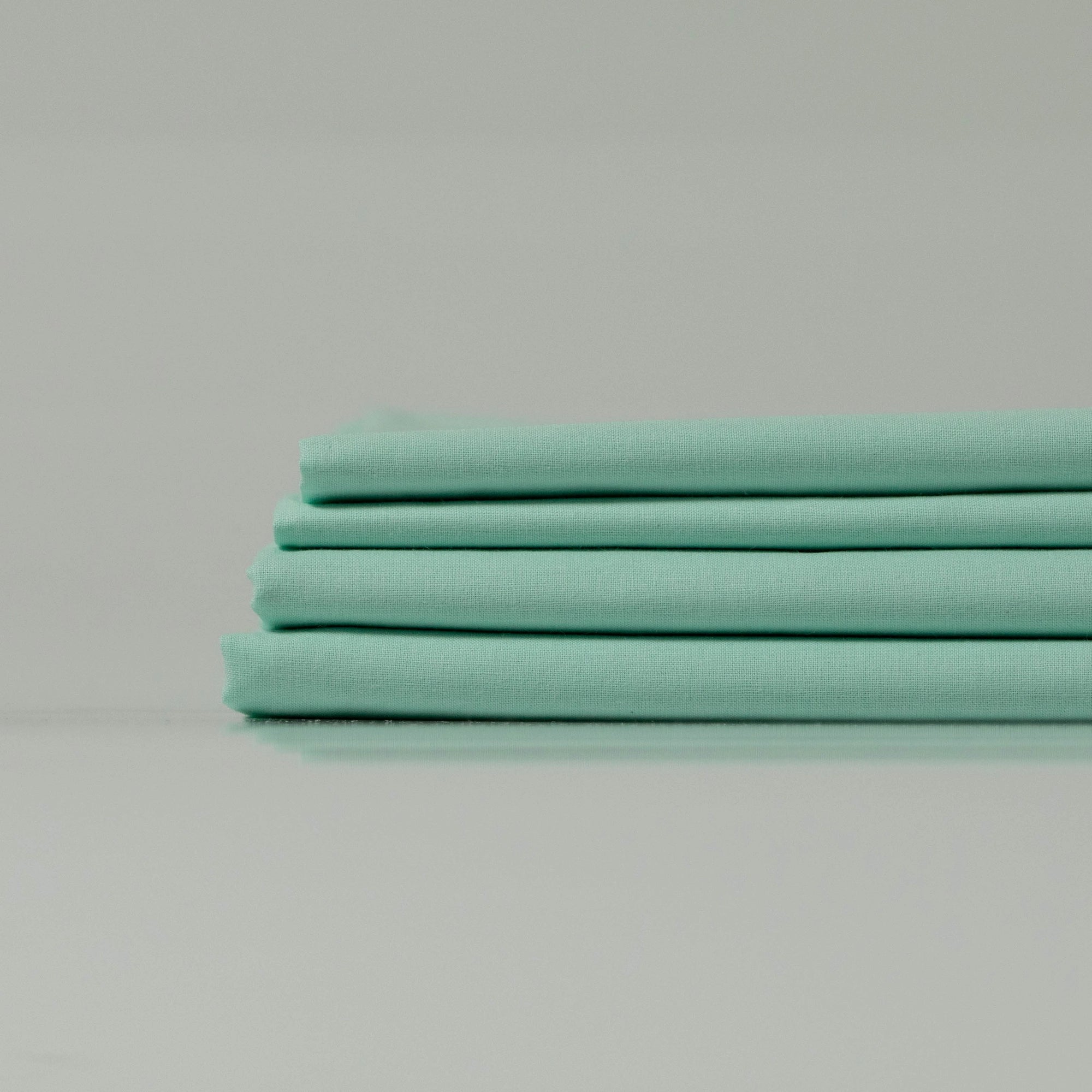 Сучасний мінімалістичний інтер’єр із м’ятною постіллю з екологічної бавовни.