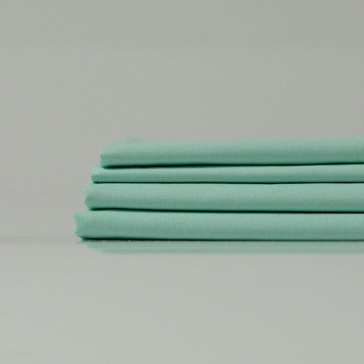 Сучасний мінімалістичний інтер’єр із м’ятною постіллю з екологічної бавовни.