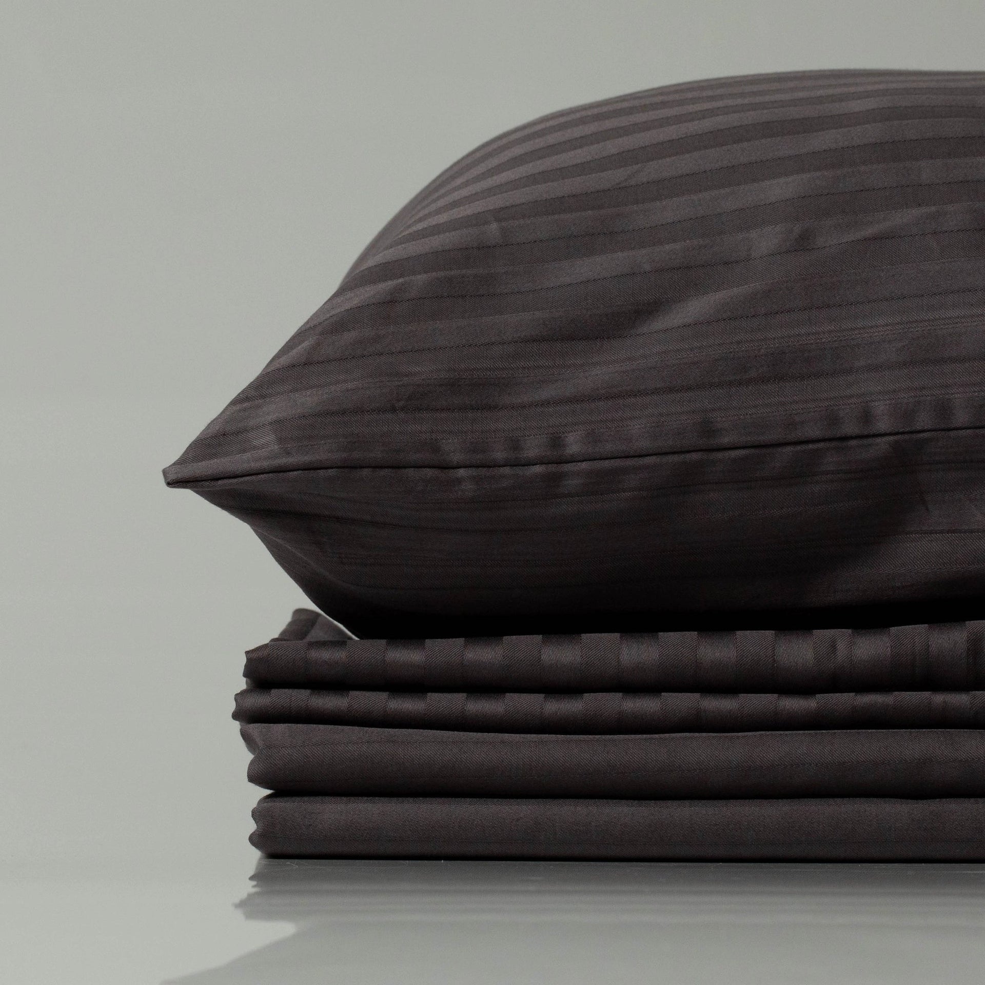 Смугаста сатинова наволочка темно-сірого кольору з органічної бавовни.