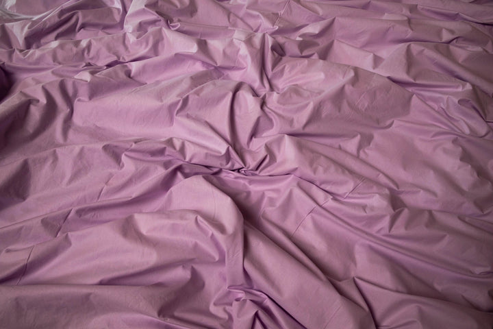 Близький план лілової тканини з легкою матовою текстурою - приємна до тіла.