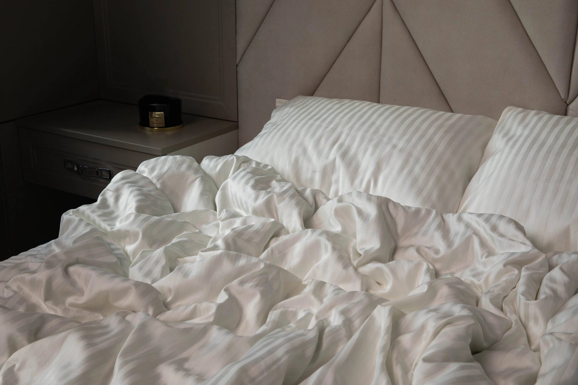 Елегантна спальня з постіллю кольору слонової кістки у стилі мінімалізм.