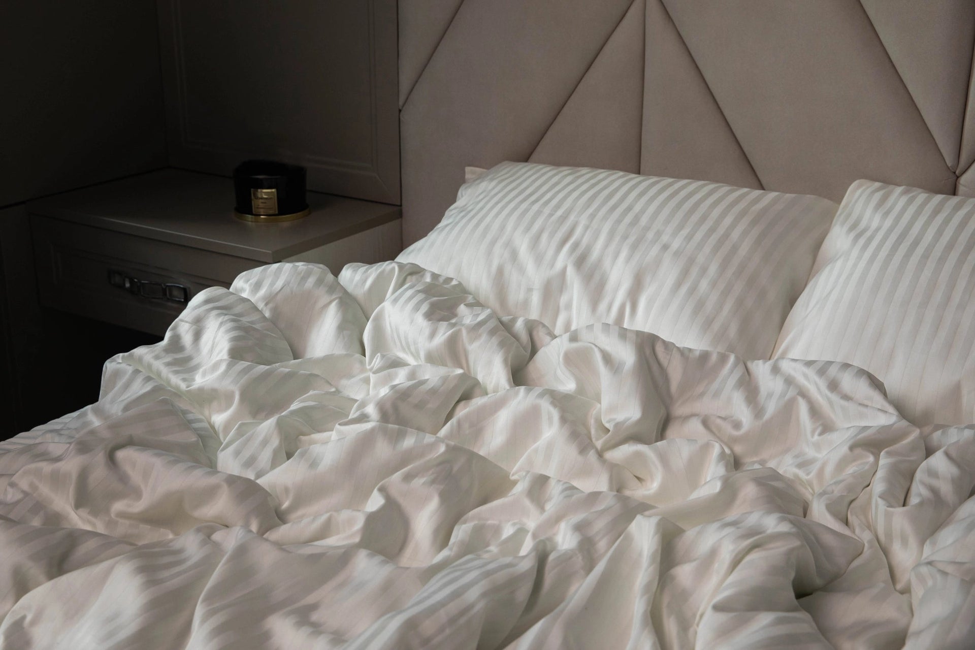 Елегантна спальня з постіллю кольору слонової кістки у стилі мінімалізм.