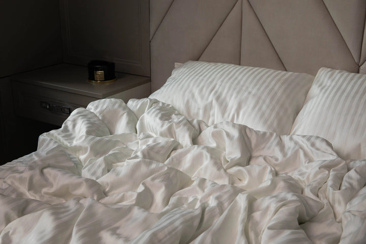 Елегантна спальня з постіллю кольору слонової кістки у стилі мінімалізм.