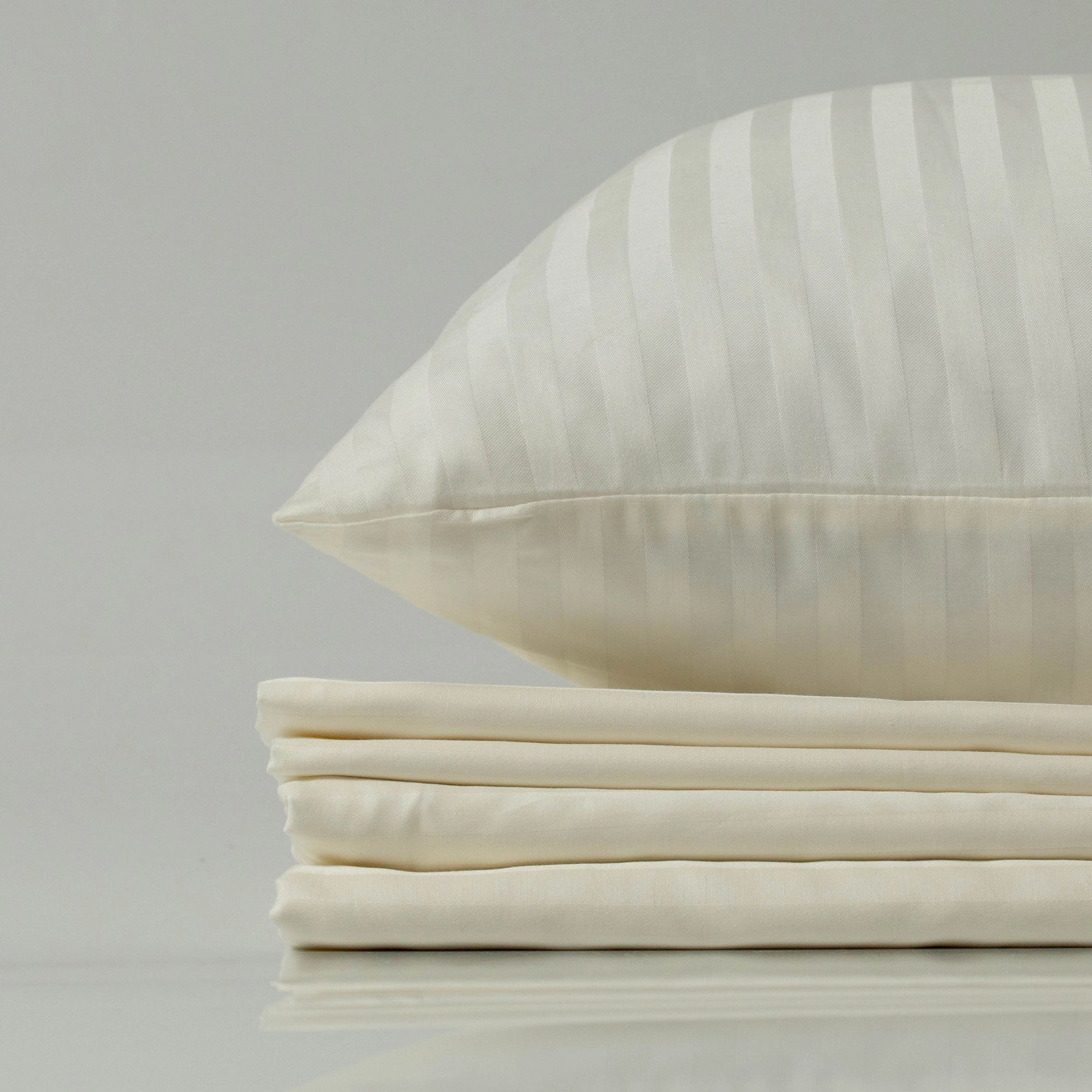 Комплект постільної білизни “Слонова Кістка” у ніжному кремовому відтінку, розкладений на ліжку.