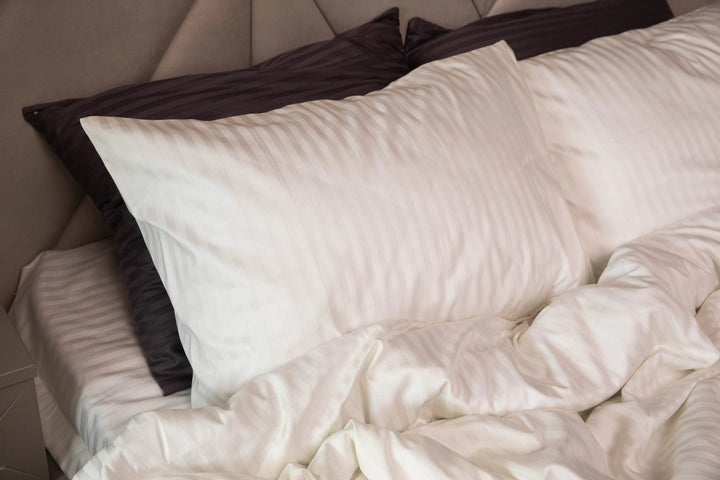 Близький план тканини страйп-сатин у кольорі слонової кістки з легким сатиновим блиском.