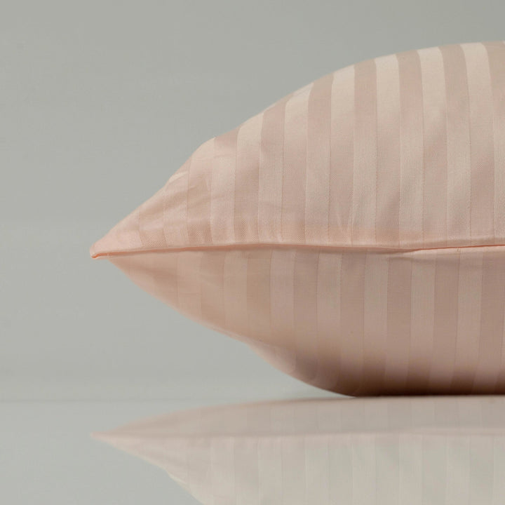 Персикова наволочка з тонкими сатиновими смужками, що підкреслюють м’якість та витончену текстуру тканини.