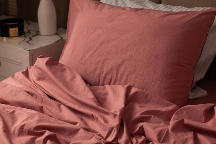 Крупний план теракотової наволочки з легкою м’ятою текстурою, що надає постелі природного й затишного вигляду.